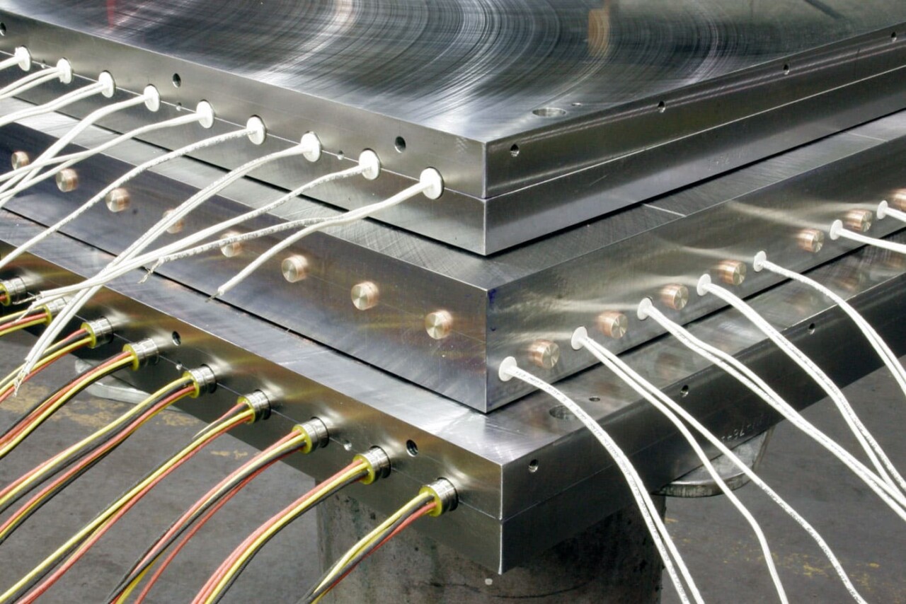 corner view of three stacked Venango electric MultiZone platens with the best heat uniformity; featuring inputs and electrical cords along edges